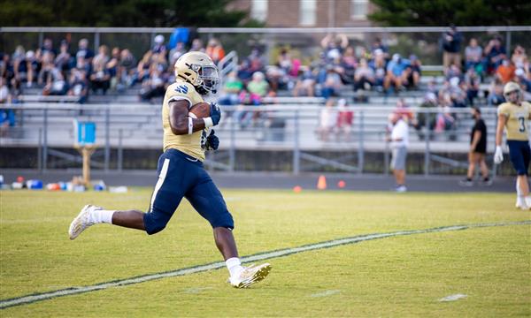 Independence High football player runs the ball down the field